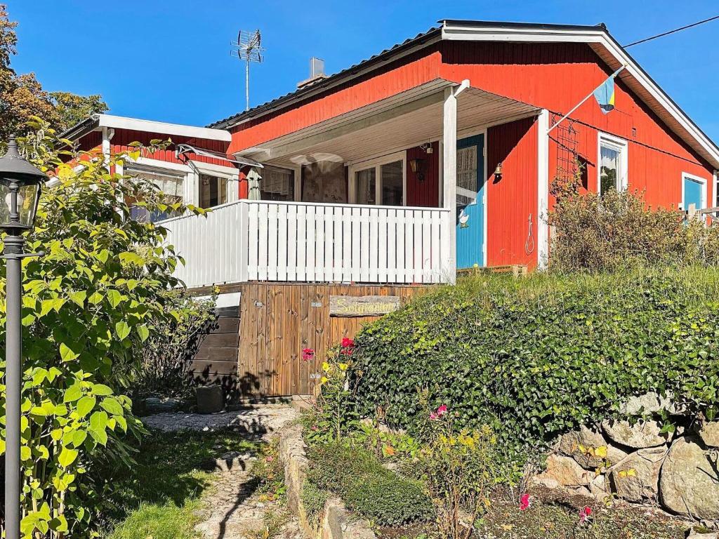 une maison rouge avec une clôture blanche devant elle dans l'établissement Holiday home FIGEHOLM, à Figeholm