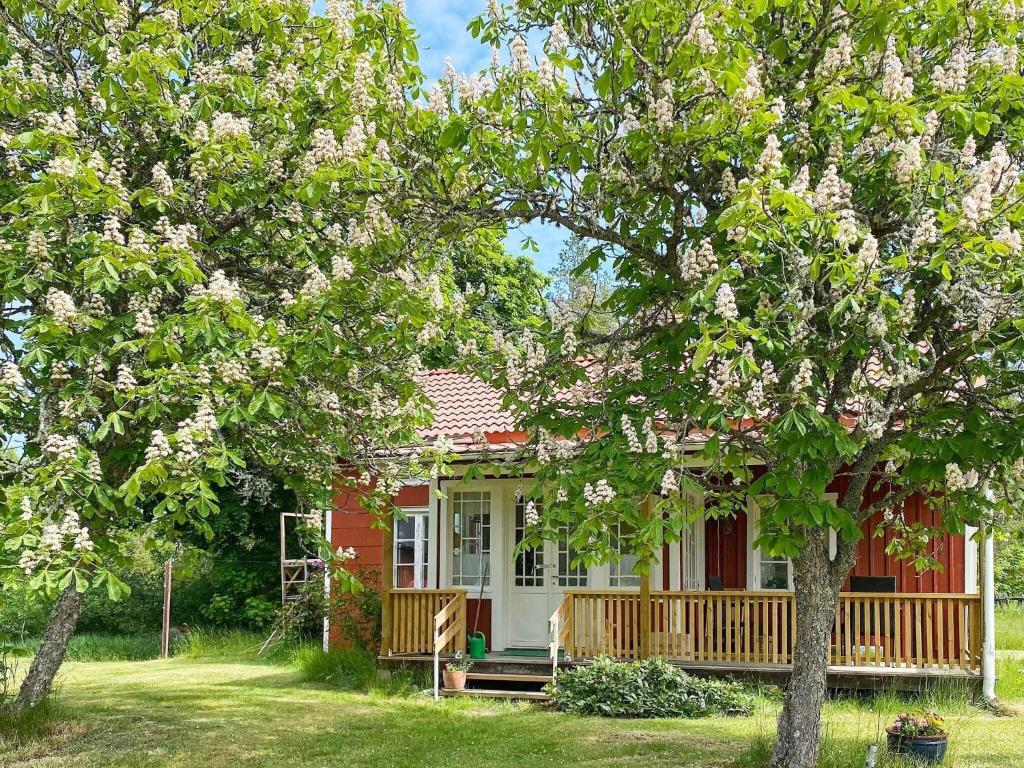 een rood-wit huis met bomen ervoor bij Holiday home NISSAFORS II 