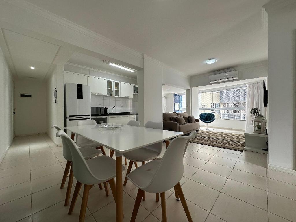 een keuken en een woonkamer met een witte tafel en stoelen bij BC01- Suíte+1 | Centro | Churrasqueira | Garagem in Balneário Camboriú