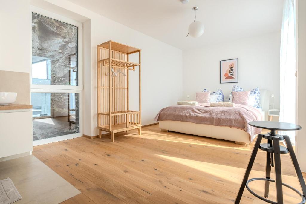 um quarto com uma cama, uma mesa e um banco em Krems Deluxe Apartments - Newly built em Krems an der Donau
