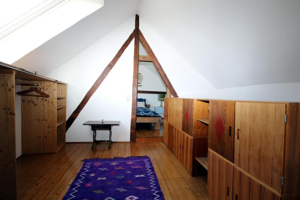 um quarto no sótão com armários de madeira e uma mesa em Gemütliches Scheunenfachwerkhaus em Bad Soden am Taunus