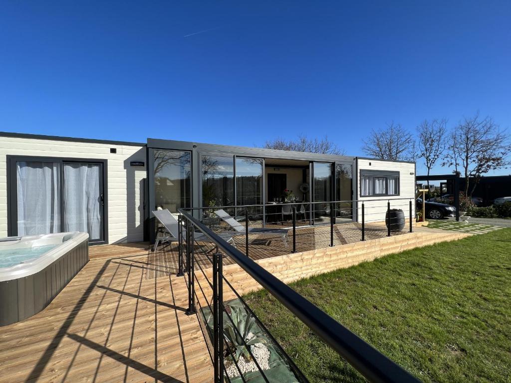ein modernes Haus mit einer Terrasse und einem Pool in der Unterkunft Cottage haut de gamme 6 personnes avec spa & wifi in Sainte-Foy