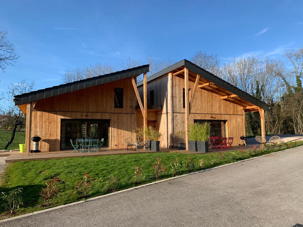 a large wooden house with a black roof at Maison Cosy 10 personnes in Clairvaux-les-Lacs
