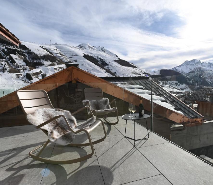 a balcony with two chairs and a view of a mountain at Horizon Blanc - Chalets dans les 2 Alpes in Les Deux Alpes
