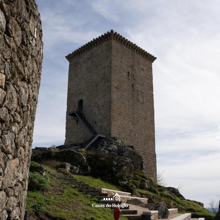 a tall brick tower on top of a hill at Casas do relógio in Penamacor
