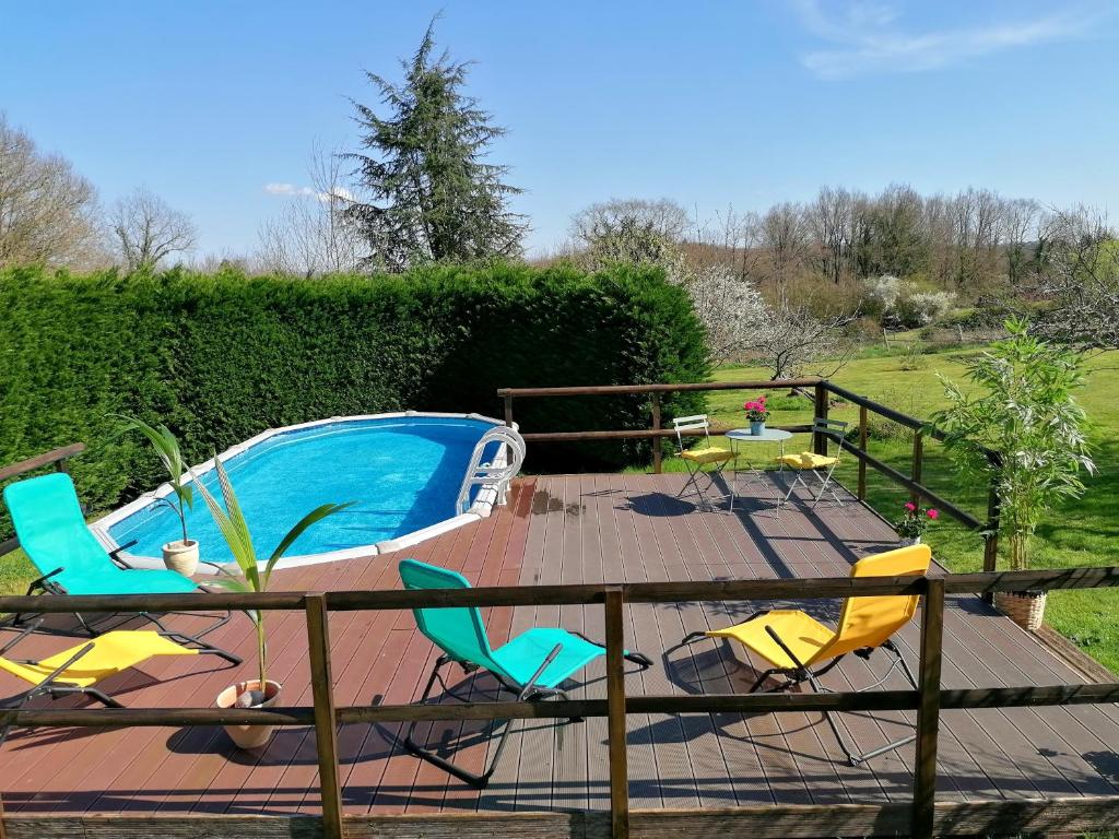 una terrazza con sedie e una piscina di Le Verger du Paradis a Beaulieu-sur-Sonnette