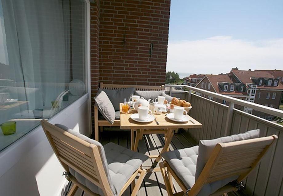 a table and chairs on a balcony with food on it at Wohnung-Kaufhold in Wittdün