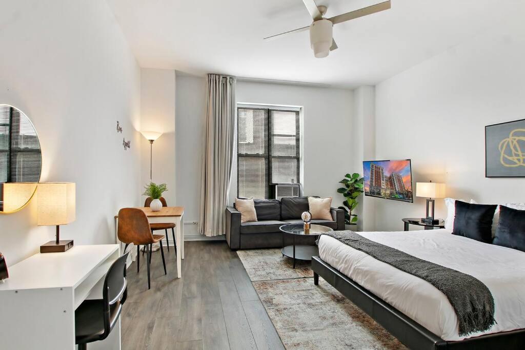 ein Schlafzimmer mit einem Bett und ein Wohnzimmer in der Unterkunft Cozy & Comfy Studio Apartment - Del Prado 418 in Chicago