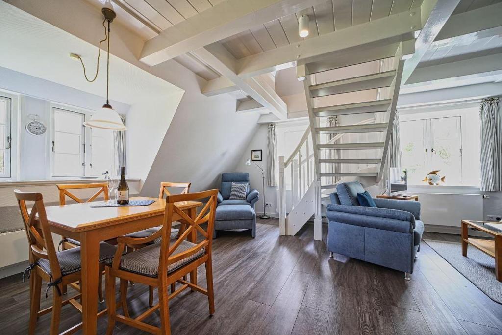 a dining room and living room with a table and chairs at Wohnung-Landwind in Süddorf