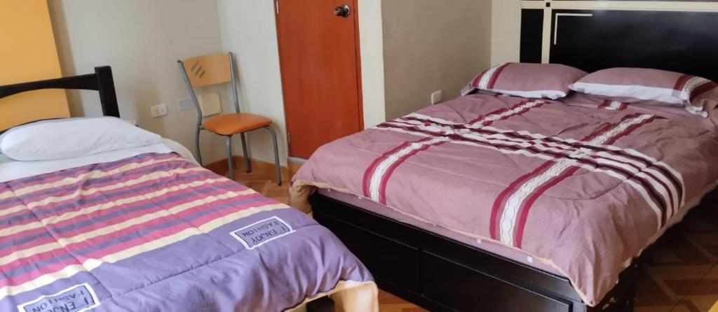 1 dormitorio con 2 camas individuales una al lado de la otra en Hostal Panoramic, en Churín