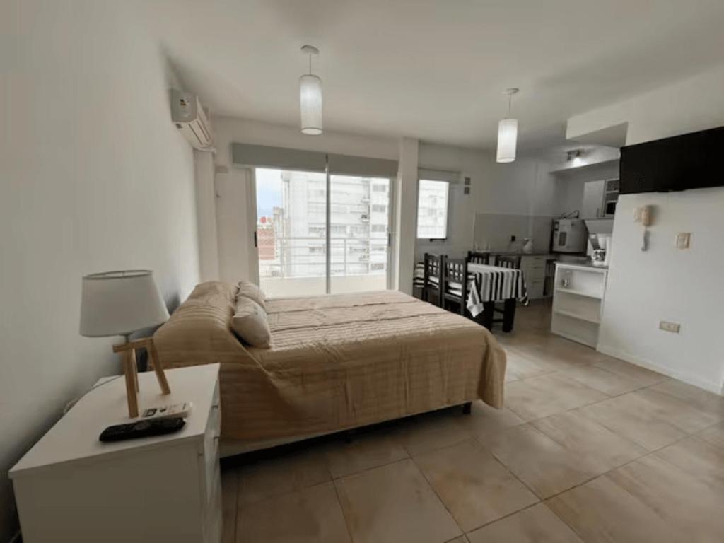 ロサリオにあるDepartamento en zona del ríoの広いベッドルーム(ベッド1台付)、キッチンが備わります。