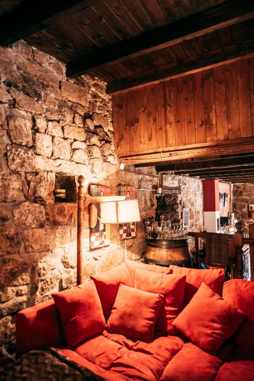 a couch in a room with a stone wall at Casa Roma in Población de Abajo