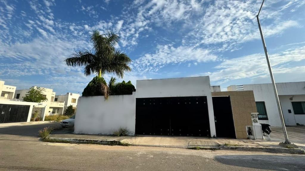 a palm tree sitting on top of a white building at Comfort and Privacy in Mérida