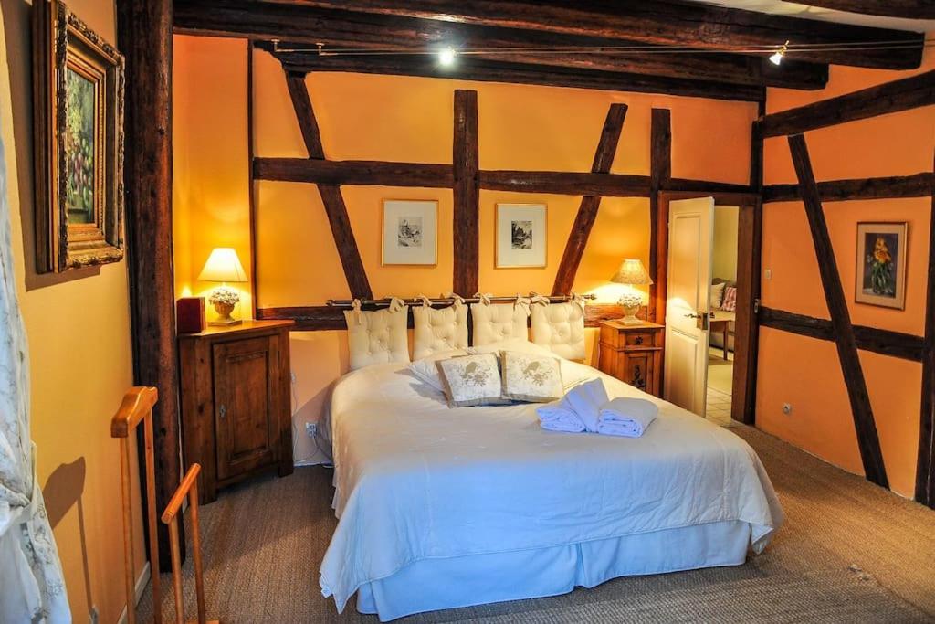 Un dormitorio con una cama grande con sábanas blancas. en Gite "Le Riesling" à Riquewihr, en Riquewihr