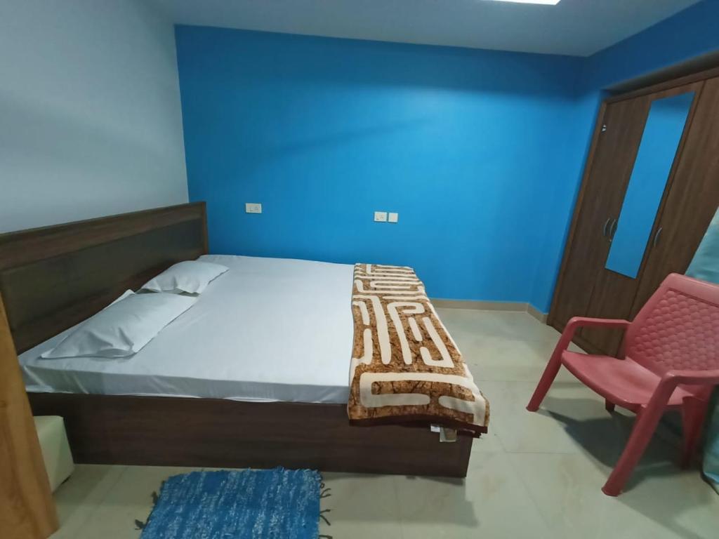 a bedroom with a bed and a red chair at Countryside Inn in Guwahati
