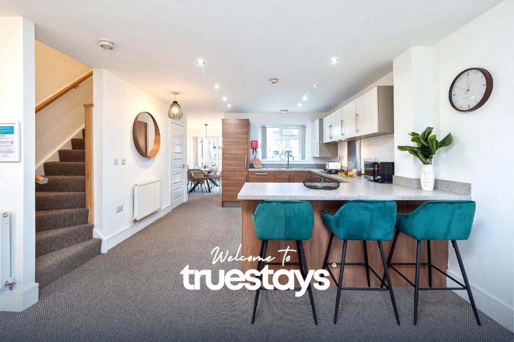 a kitchen and living room with a counter and stools at Kempthorne House by Truestays - NEW Entire House near Alton Towers in Etruria