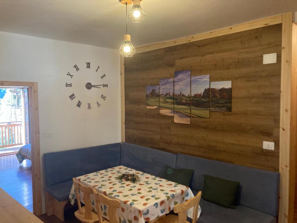 a dining room with a table and a clock on the wall at Casa vacanza Emi in Bocenago