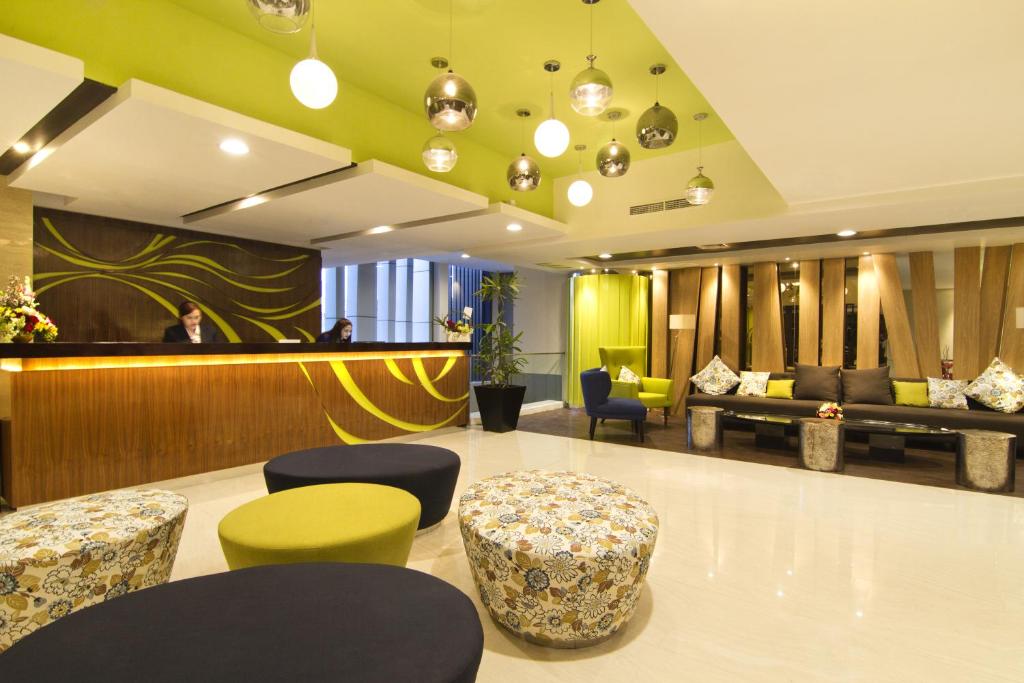 a lobby with a waiting room with chairs and a bar at Bonnet Hotel Surabaya in Surabaya