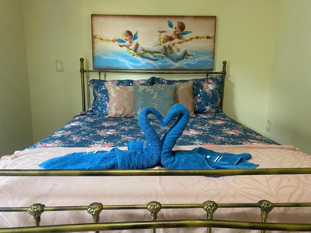 - un lit avec 2 serviettes bleues dans l'établissement Quarto Casal, Wi-Fi, Piscina, Praia, à Vila Velha
