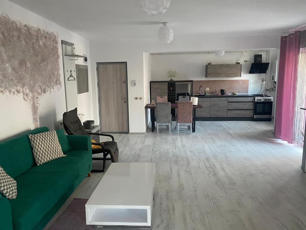 sala de estar con sofá verde y cocina en RMS Residence, en Floreşti