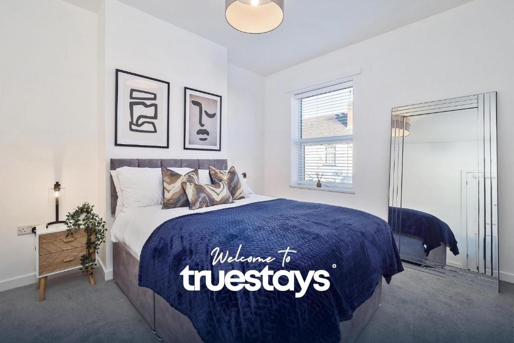 a bedroom with a bed with a blue comforter at Nursery House by Truestays - 3 Bedroom House in Stoke-on-Trent in Stoke on Trent