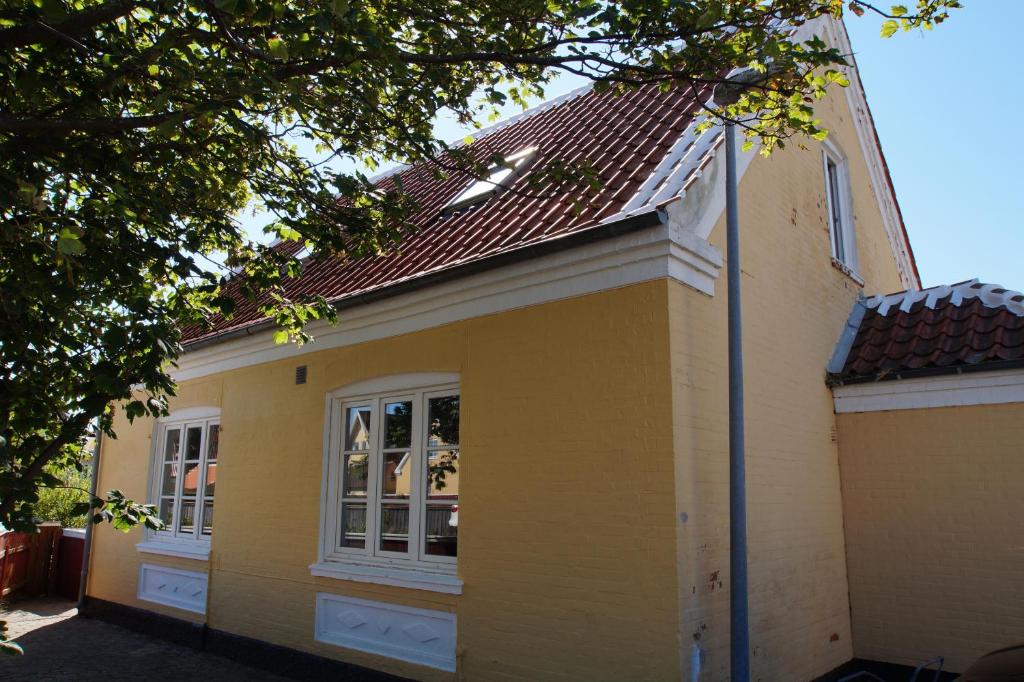 a yellow house with a red roof at Foldens Hotel Annex in Skagen