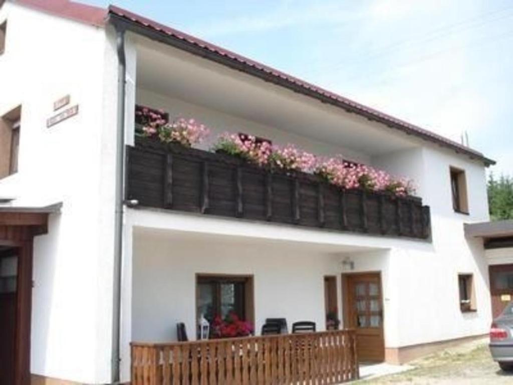 a white house with a balcony with flowers on it at Haus Steinwaldblick in Brand