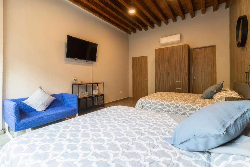 a bedroom with two beds and a tv on the wall at 105 Centrico Zocalo apt 2Bdrm 2bath AC Rooftop in Mexico City