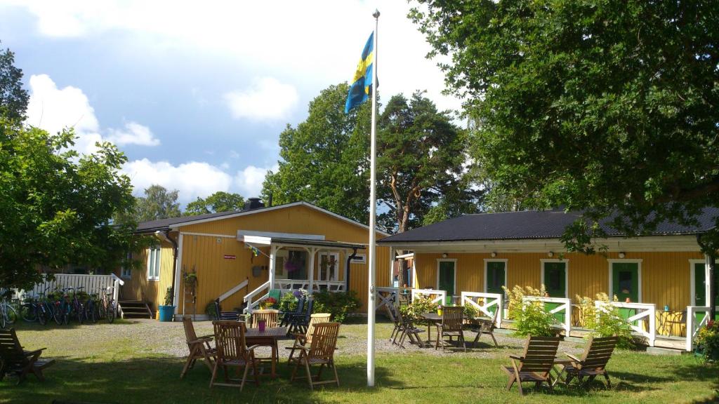 uma casa amarela com um mastro de bandeira em frente em Lilla Hotellet em Västervik