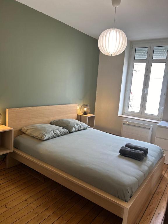 sypialnia z dużym łóżkiem z czarnym przedmiotem w obiekcie Le petit Universel w mieście Wimereux