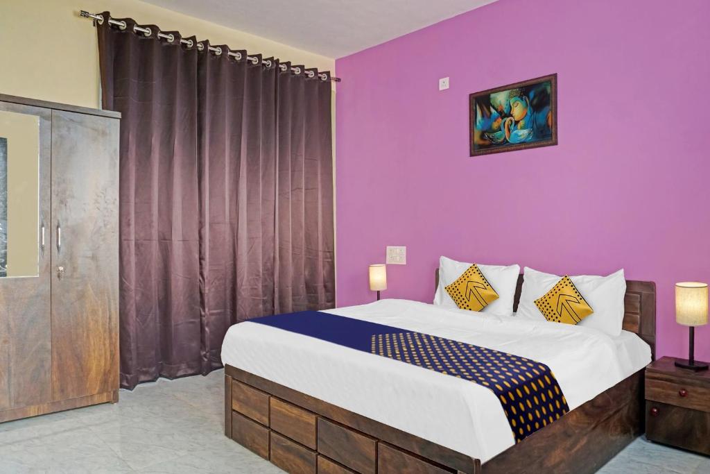 ein Schlafzimmer mit einem großen Bett mit lila Wänden in der Unterkunft OYO MYRA SERVICED APARTMENTS in Lohogaon