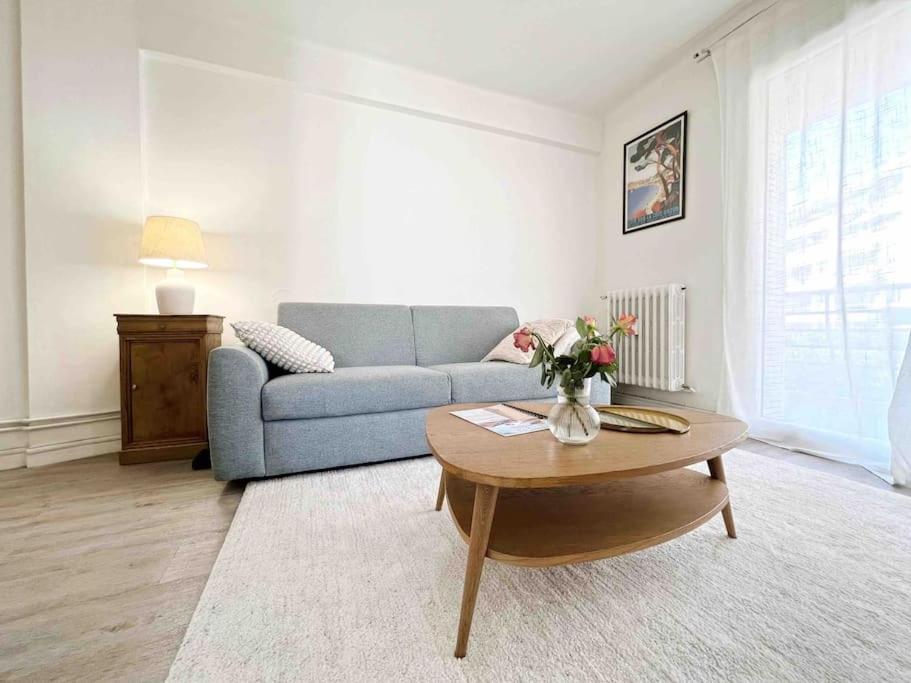 un salon avec un canapé bleu et une table dans l'établissement Le Diderot : Apt 2 Prs, 10 min plages, parking, à Antibes