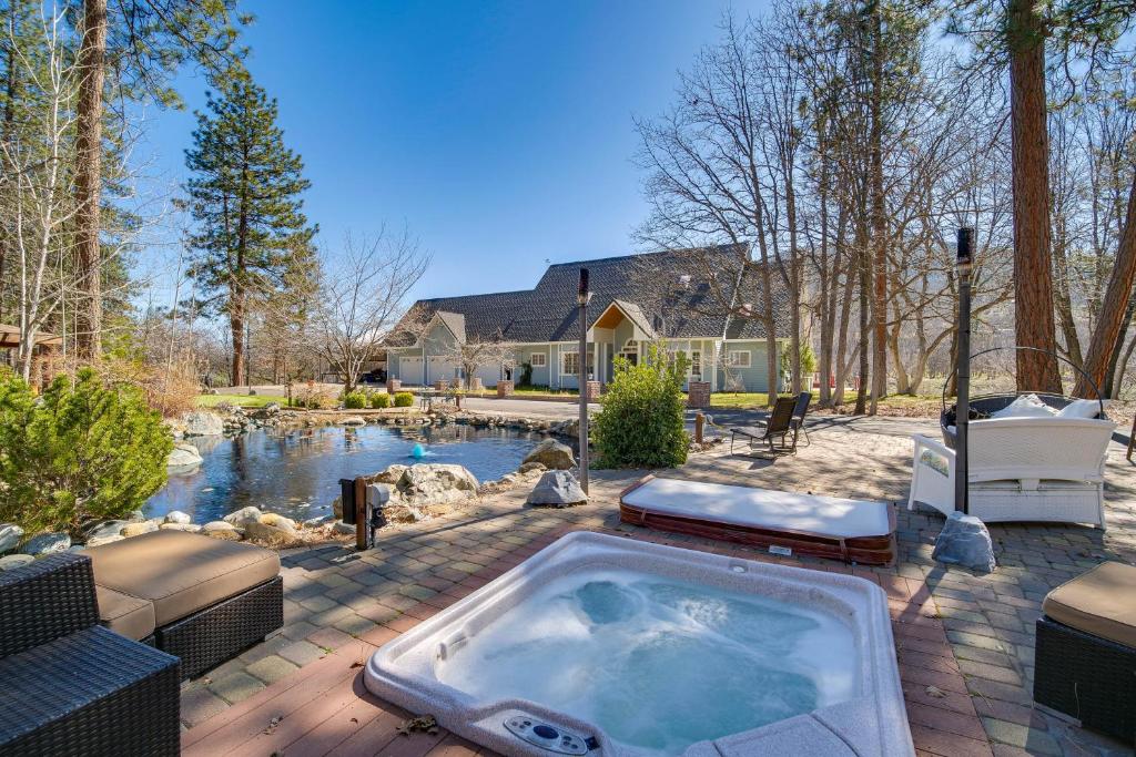 un patio trasero con bañera de hidromasaje y estanque en Yreka Home with Outdoor Oasis on 20 Wooded Acres!, en Yreka