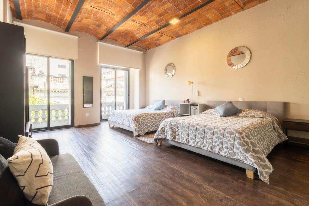 a bedroom with two beds and a couch at 204 Historic Center 2Bdrm 2Bath AC Apt Rooftop in Mexico City