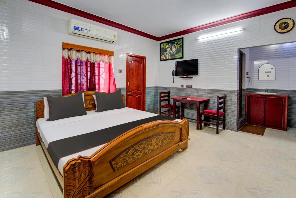 1 dormitorio con cama, mesa y TV en Nestle Inn Near Fortune Tower, en Chennai