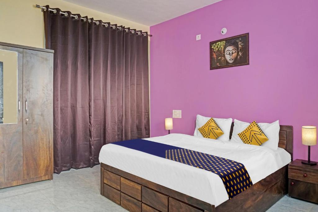 um quarto com uma cama grande e paredes roxas em OYO MYRA SERVICED APARTMENTS em Lohogaon