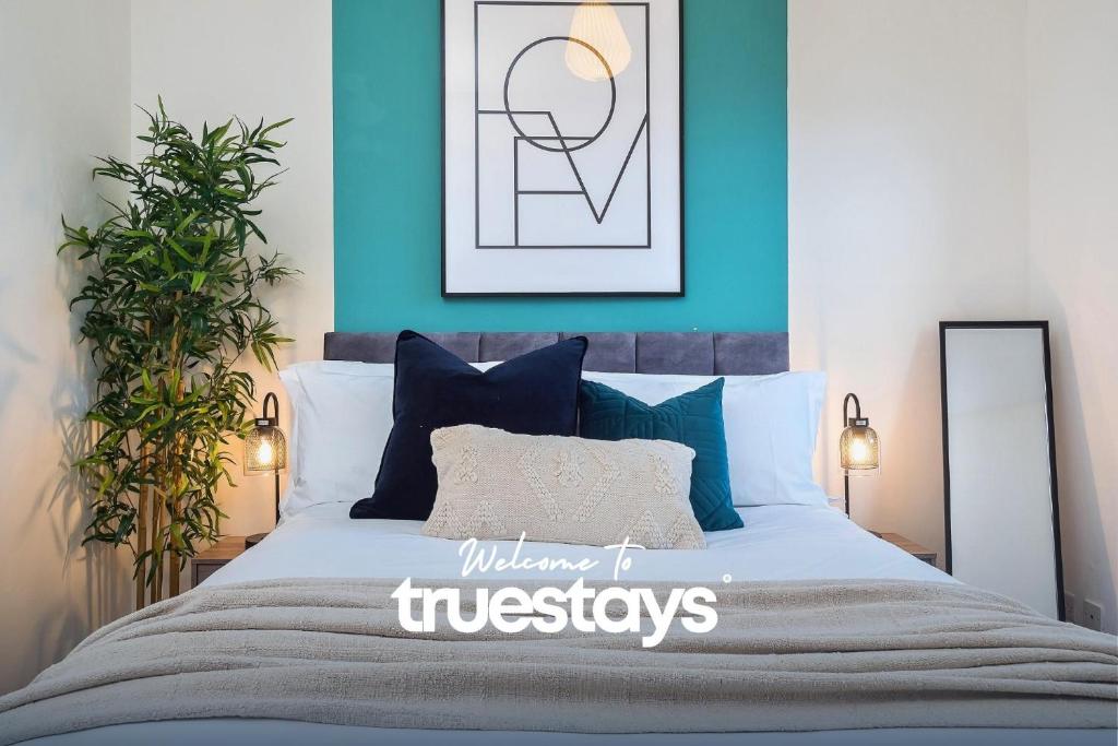 ein Schlafzimmer mit einem großen Bett mit blauen Wänden in der Unterkunft Penkhull House by Truestays - 4 Bedroom House in Stoke-on-Trent in Stoke on Trent