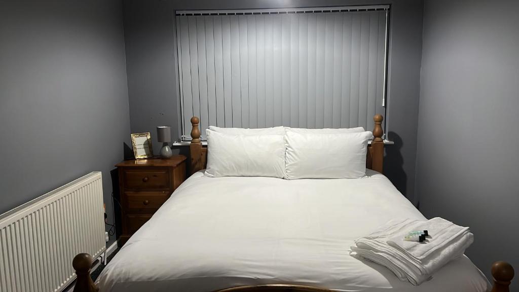 ein Schlafzimmer mit einem großen Bett mit weißer Bettwäsche in der Unterkunft Becky's Lodge - Strictly Single Adult Room Stays - No Double Adult Stays Allowed in Solihull