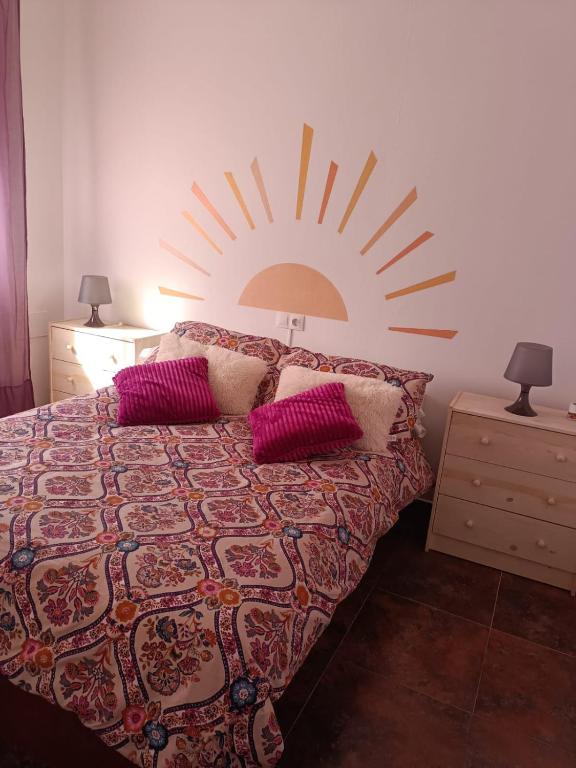 a bedroom with a bed with a sun on the wall at La Casa de Maia in Freila