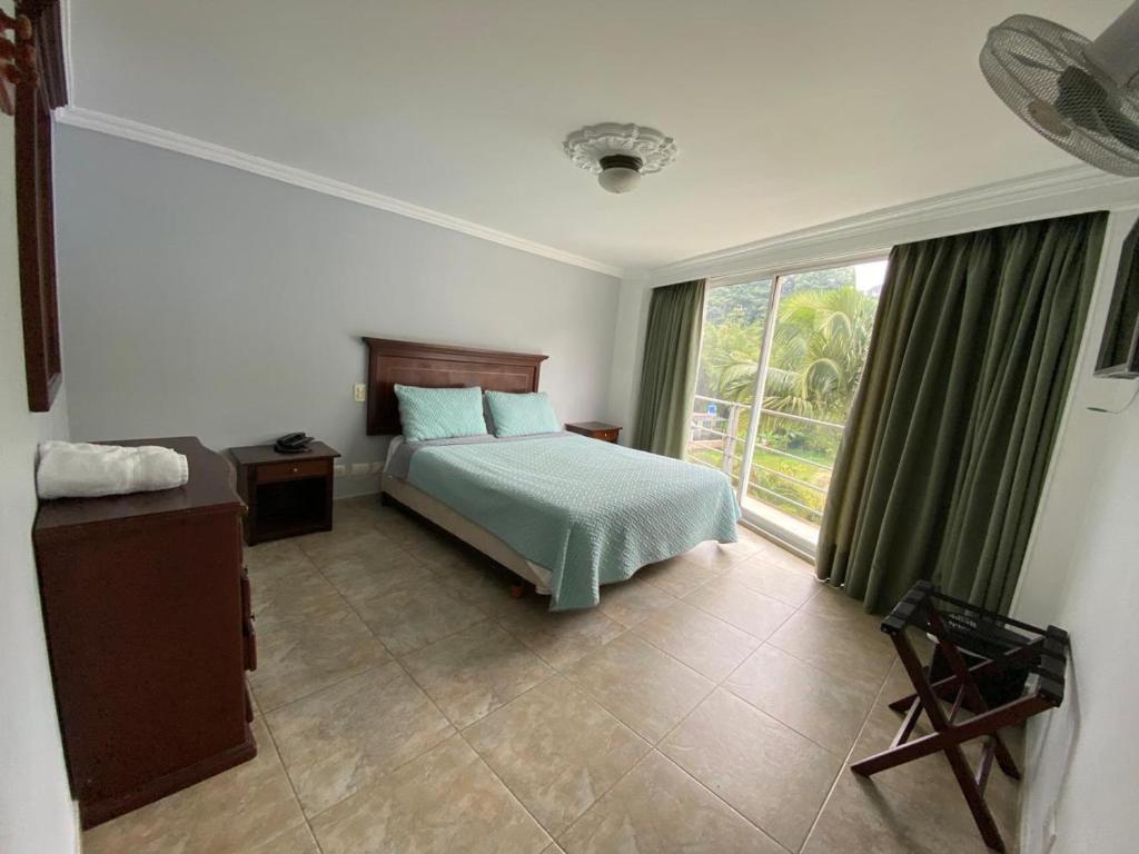 a bedroom with a bed and a large window at Juan de la vega in La Vega