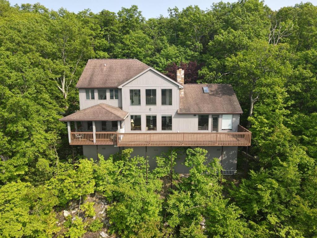 an aerial view of a house in the trees at Panorama Peak View- Wifi, Screen Porch, Million Dollar View, Fireplace, Full Kitchen in Berkeley Springs