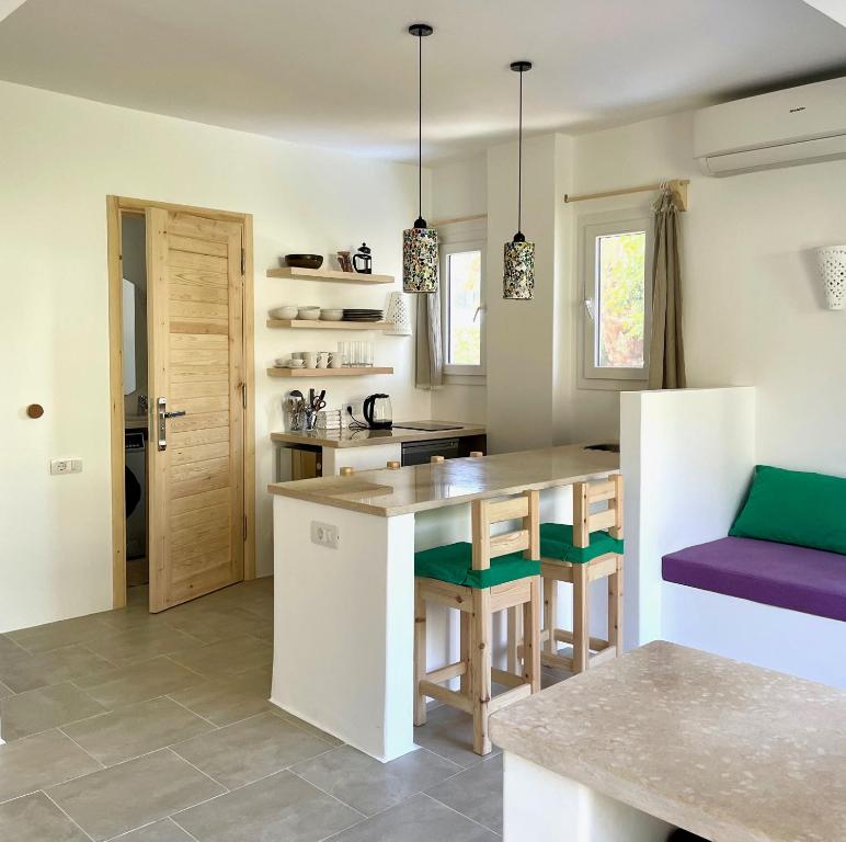 uma cozinha com uma ilha de cozinha com assentos verdes em Lagoon Apartment em Dahab
