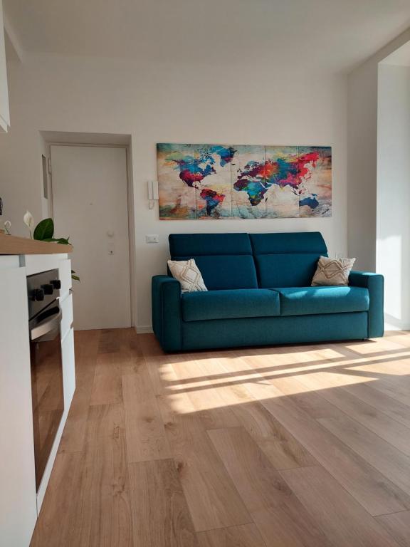 Casa Mappamondo في ليكو: غرفة معيشة بها أريكة زرقاء و لوحة