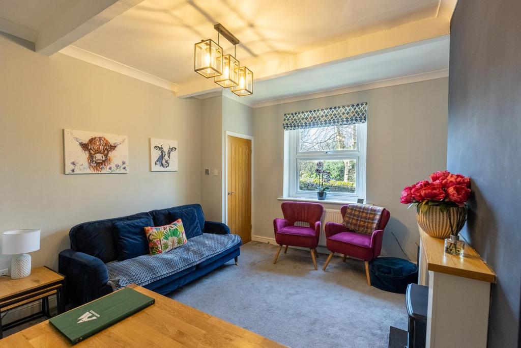 a living room with a blue couch and two red chairs at LITTLE RED HOLIDAY HOME - 2 Bed House with Free Parking within West Yorkshire, local access to the Peak District in Halifax