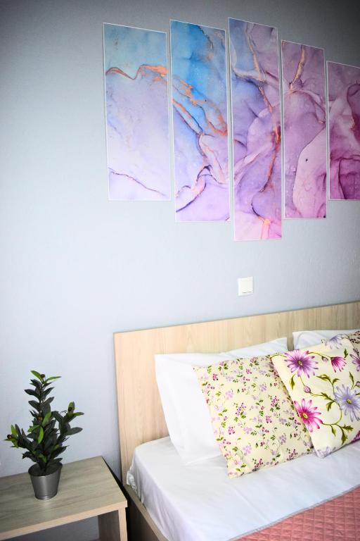 a bedroom with four paintings on the wall at Venice Apartments in Limenaria