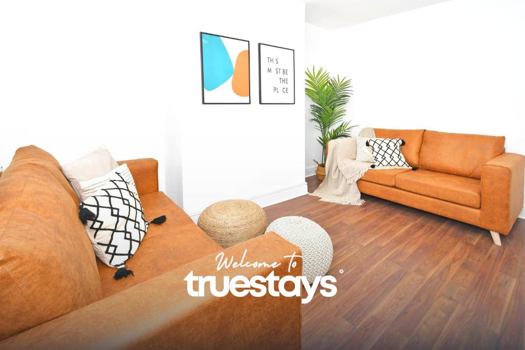 a living room with a couch and a chair at Gilman House by Truestays - 4 Bedroom House in Stoke-on-Trent in Etruria