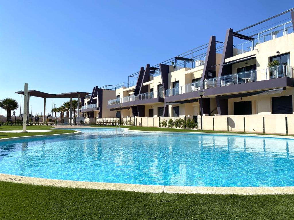 a large swimming pool in front of a building at Precioso apartamento a tan solo 300 m de la playa in Pilar de la Horadada