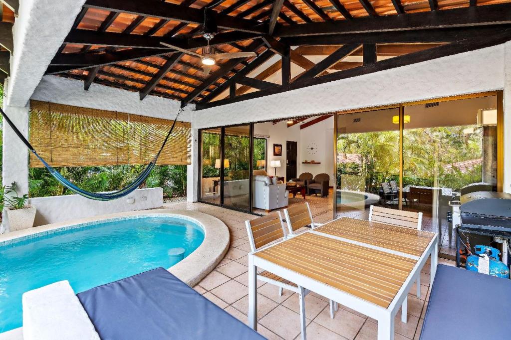 a patio with a table and a swimming pool at Peaceful Garden Villa in Sardinal