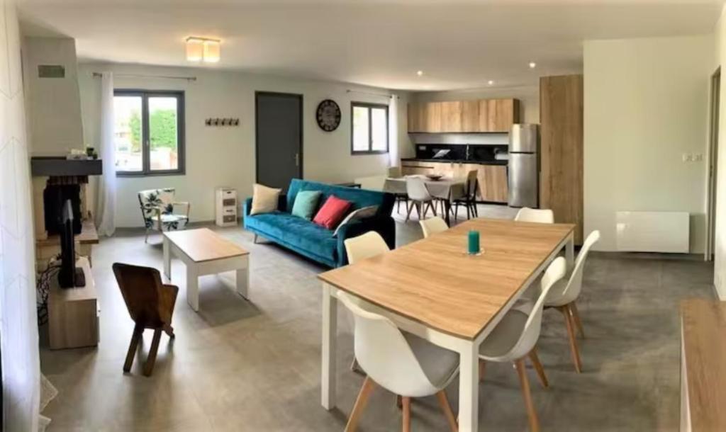 un salon avec un canapé bleu et une table dans l'établissement Maison landaise contemporaine, à Andernos-les-Bains