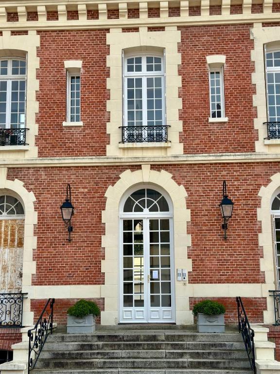 a brick building with stairs in front of it at Le Grand Galop - Duplex in Deauville